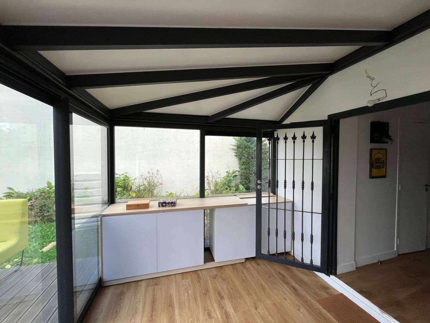 Véranda moderne avec baies vitrées et structure métallique élégante