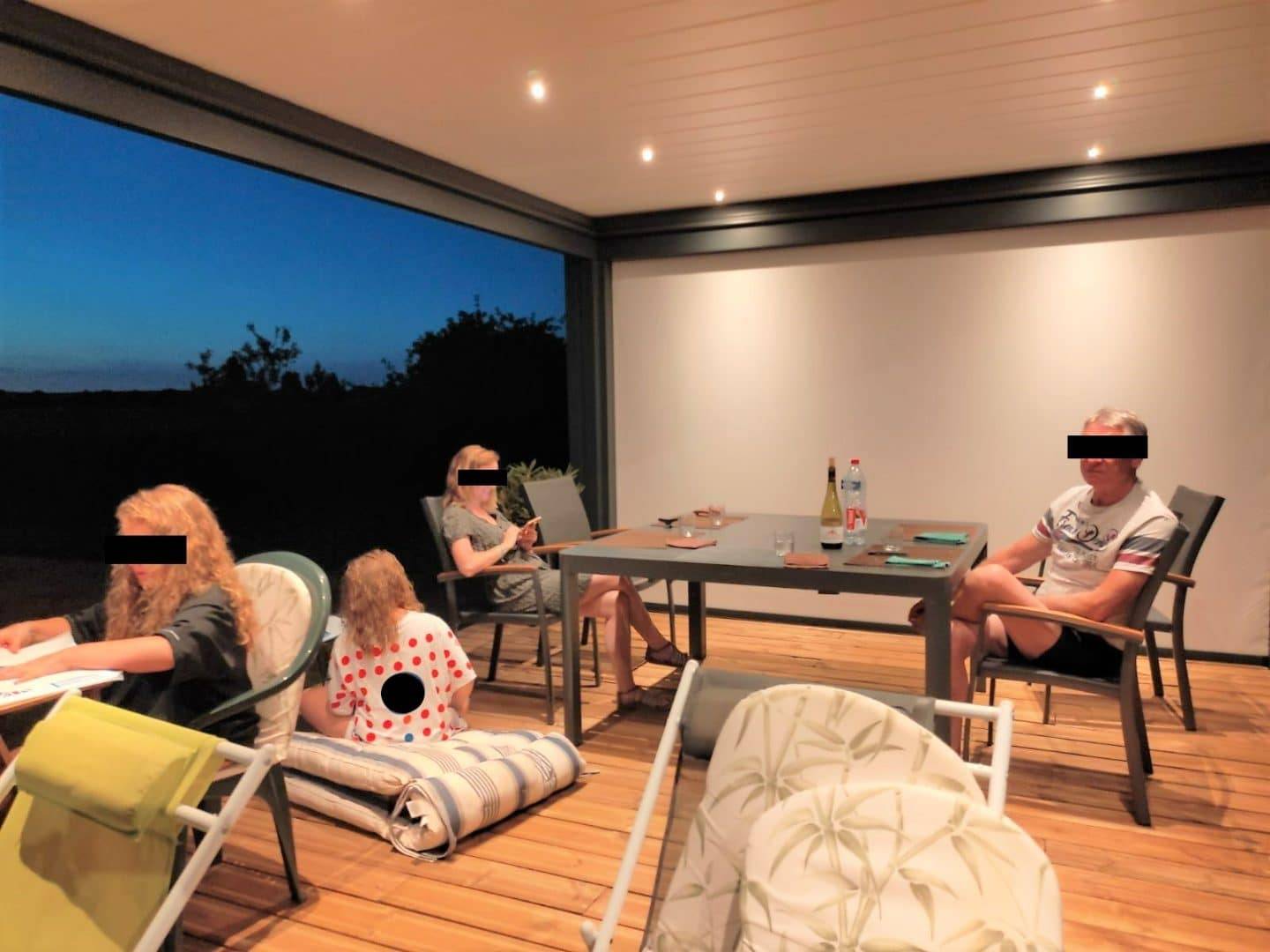Soirée conviviale sous une pergola moderne accueillante et lumineuse