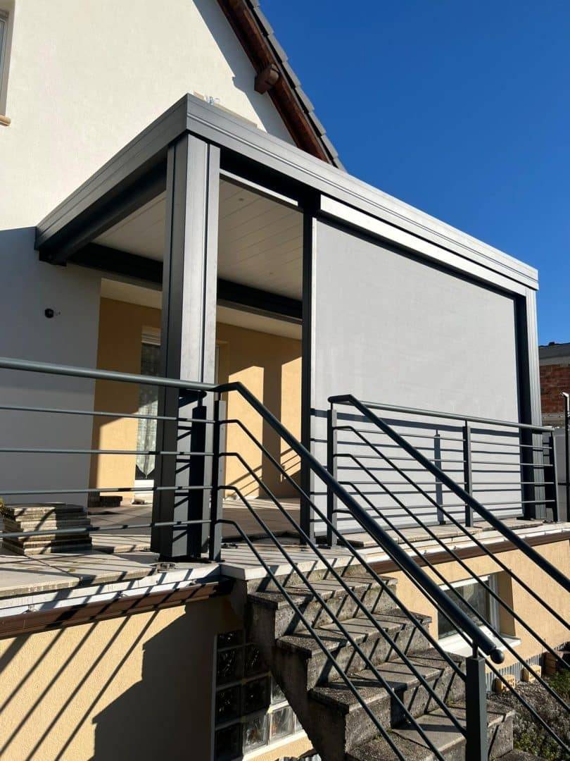 Véranda moderne en métal adossée à une maison avec escalier