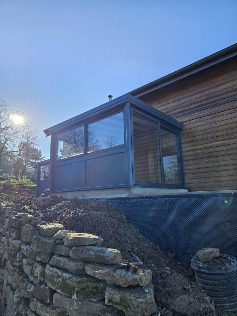 Véranda moderne en aluminium intégrée à maison en bois