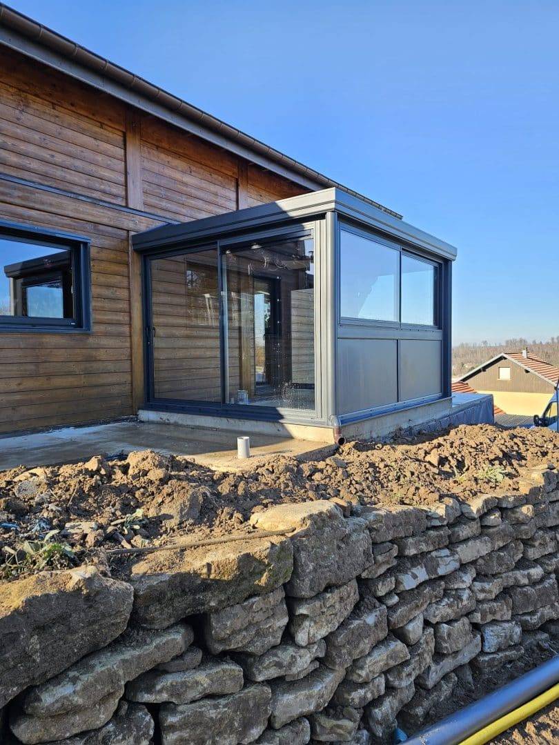 Véranda moderne en aluminium annexée à une maison en bois