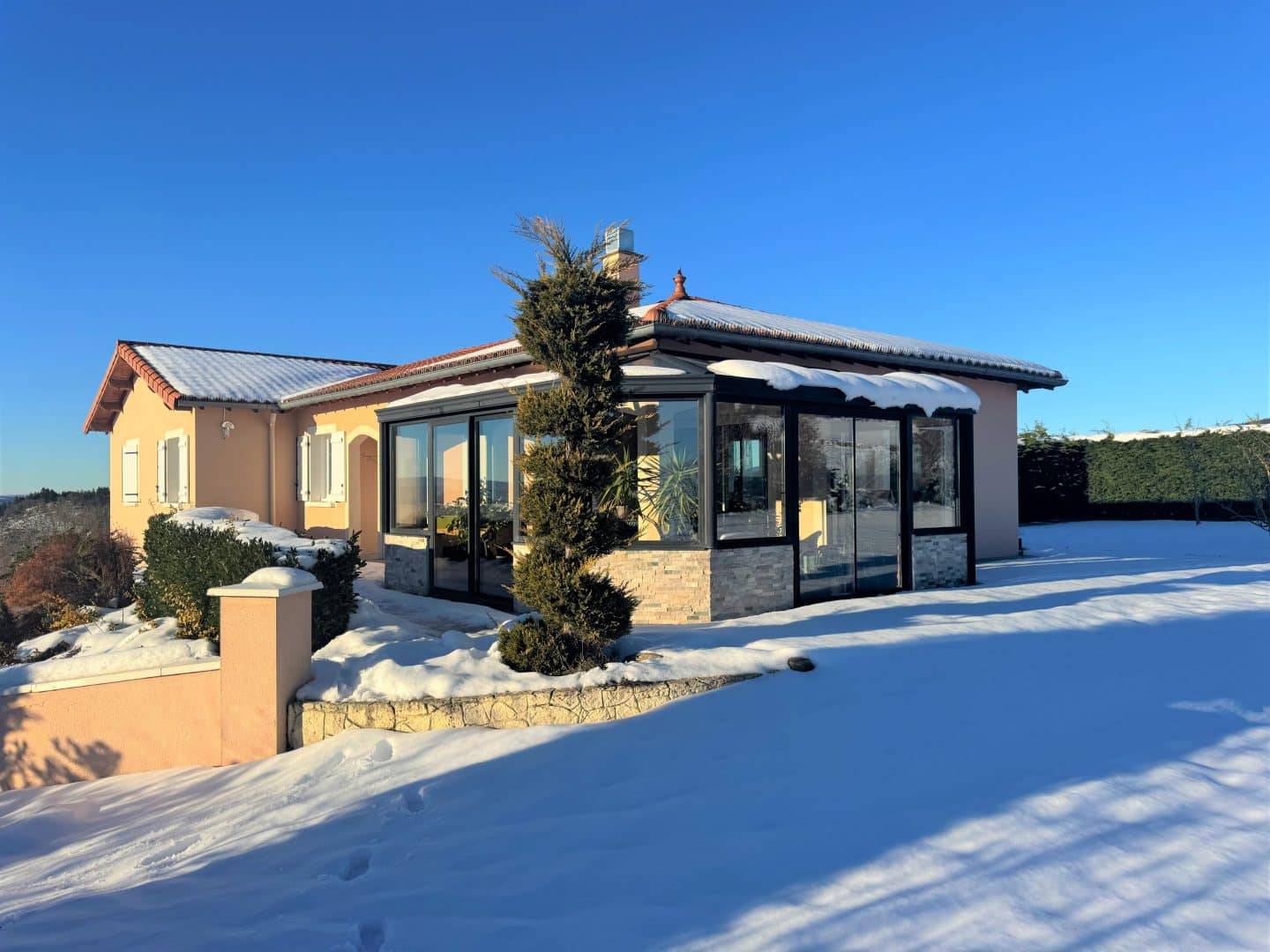 Véranda moderne ensoleillée avec vue imprenable sur le paysage enneigé