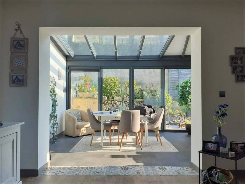 20240423_091531 Véranda lumineuse avec mobilier moderne et vue sur jardin