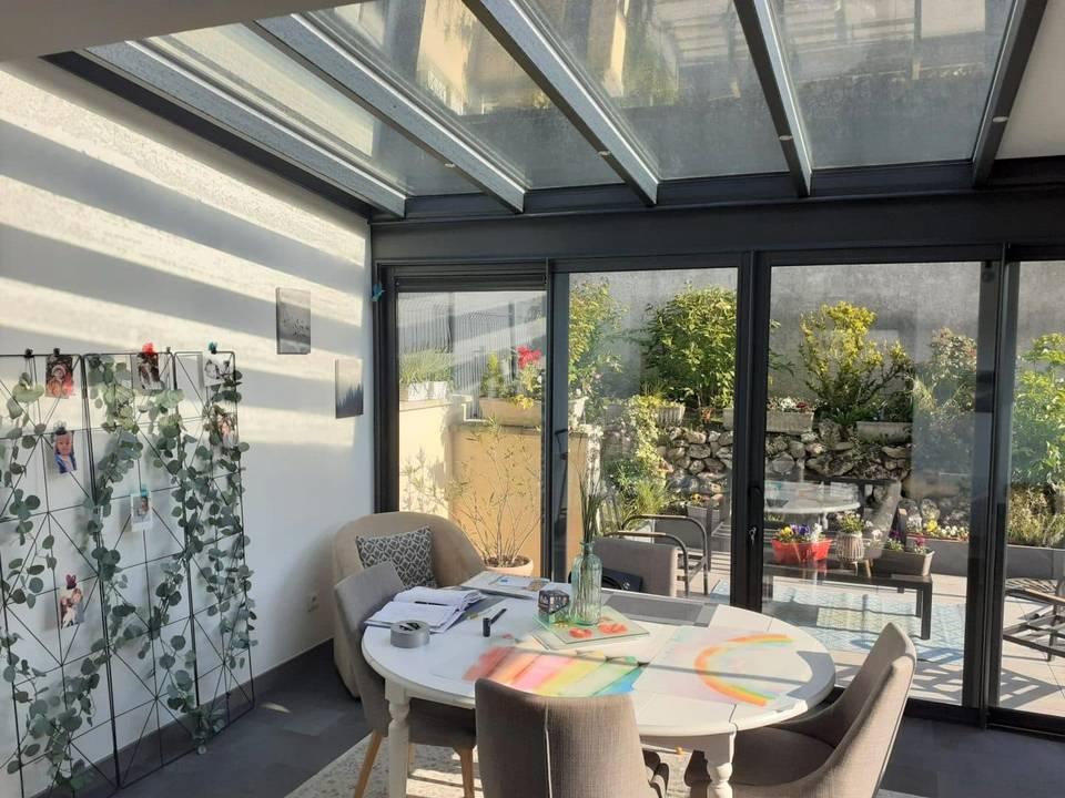 20240423_091623 Véranda lumineuse avec mobilier moderne et vue sur jardin verdoyant