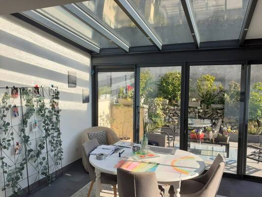20240423_091623 Véranda lumineuse avec mobilier moderne et vue sur jardin verdoyant