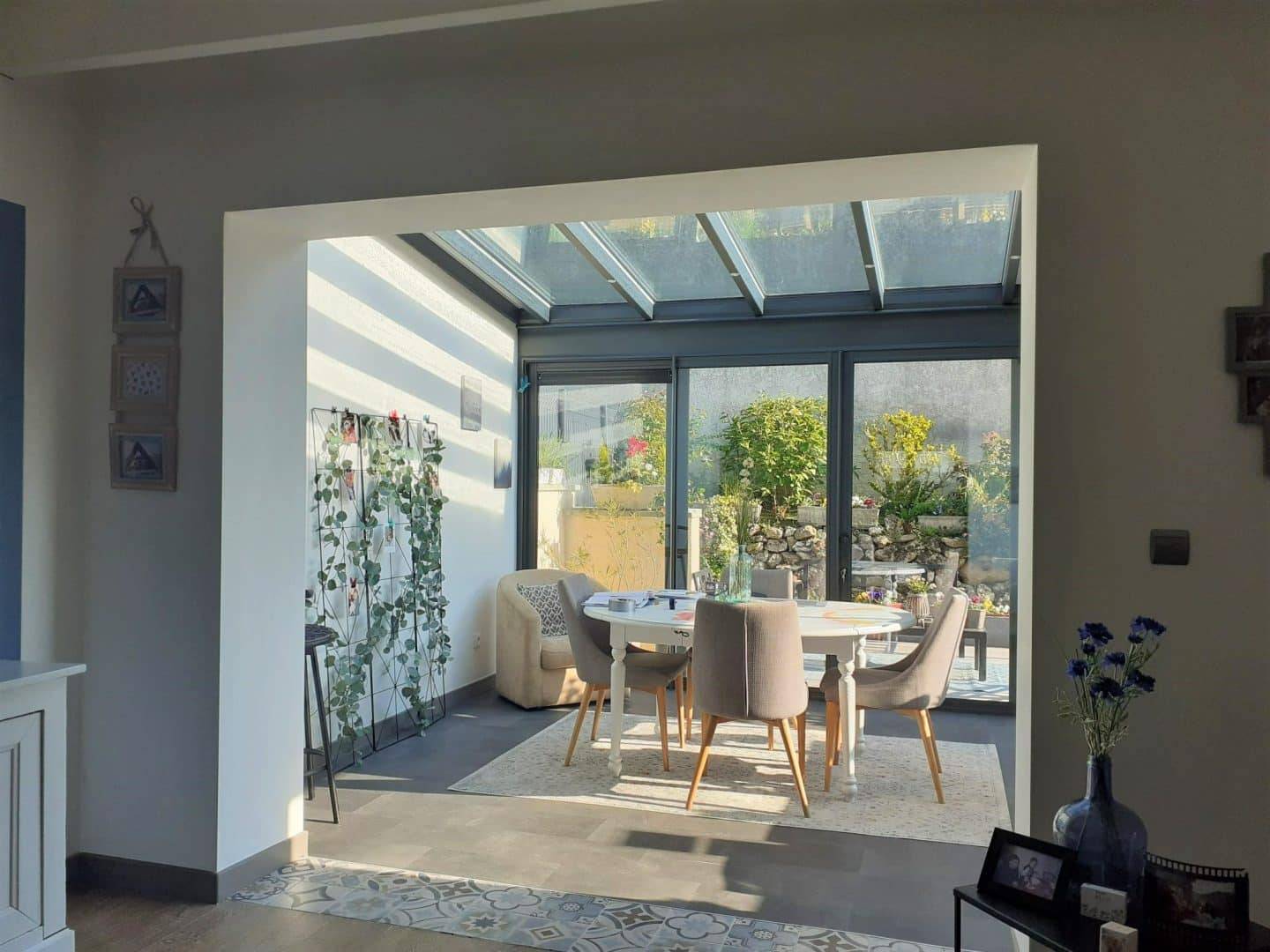 Véranda moderne lumineuse avec vue sur jardin verdoyant intégré