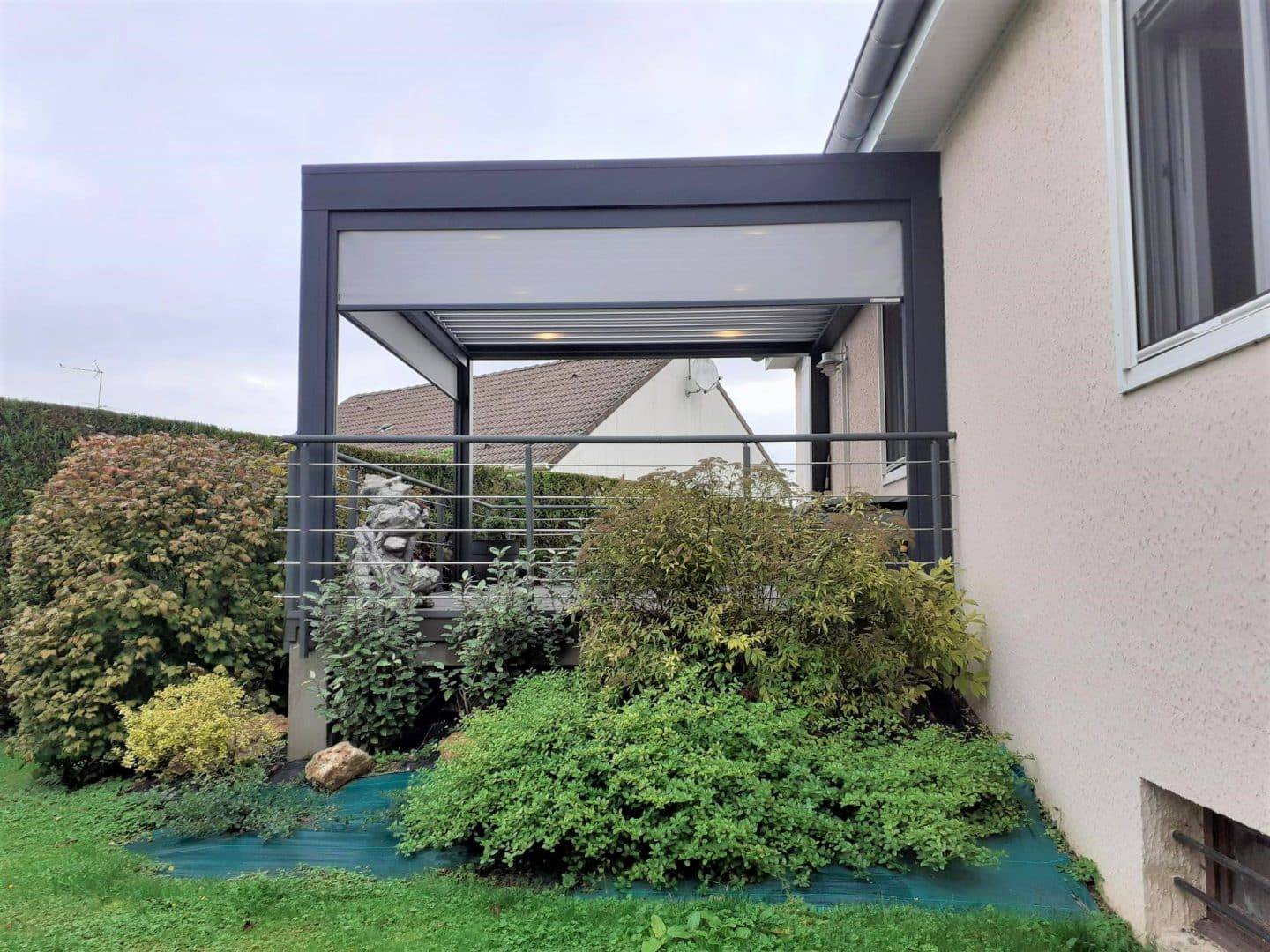 Pergola moderne attachée à une maison dans un jardin verdoyant