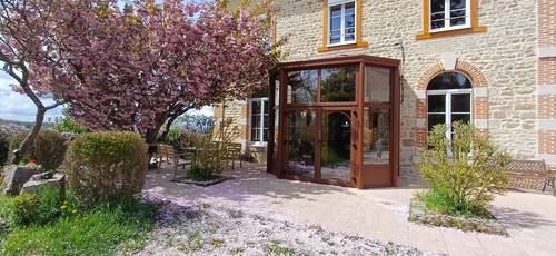 20250422_150047 Véranda élégante en bois intégrée à une maison en pierre