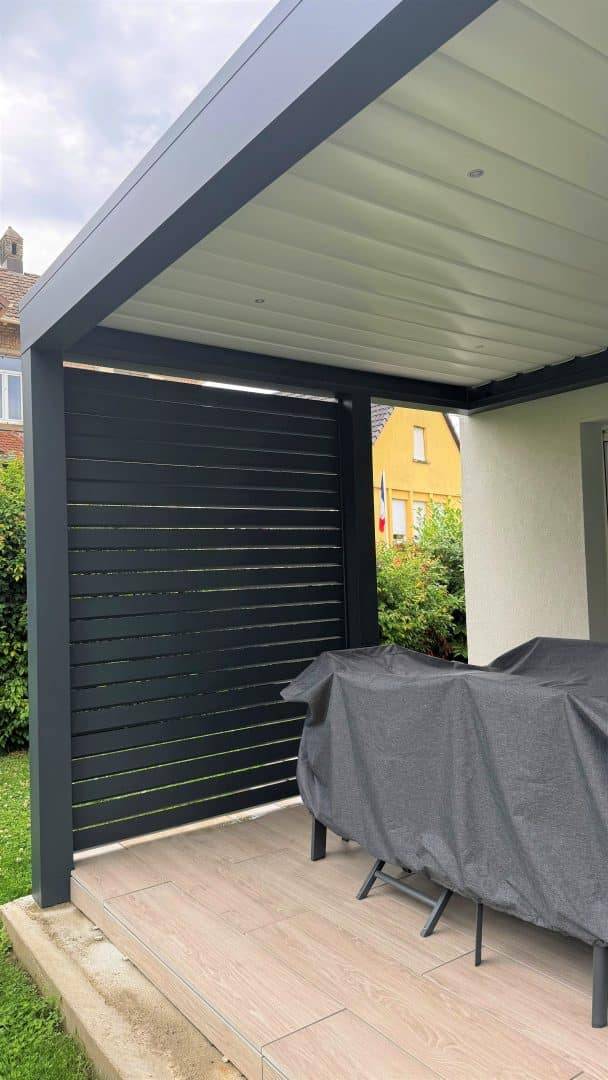 Pergola moderne en métal installée sur terrasse élégante boisée