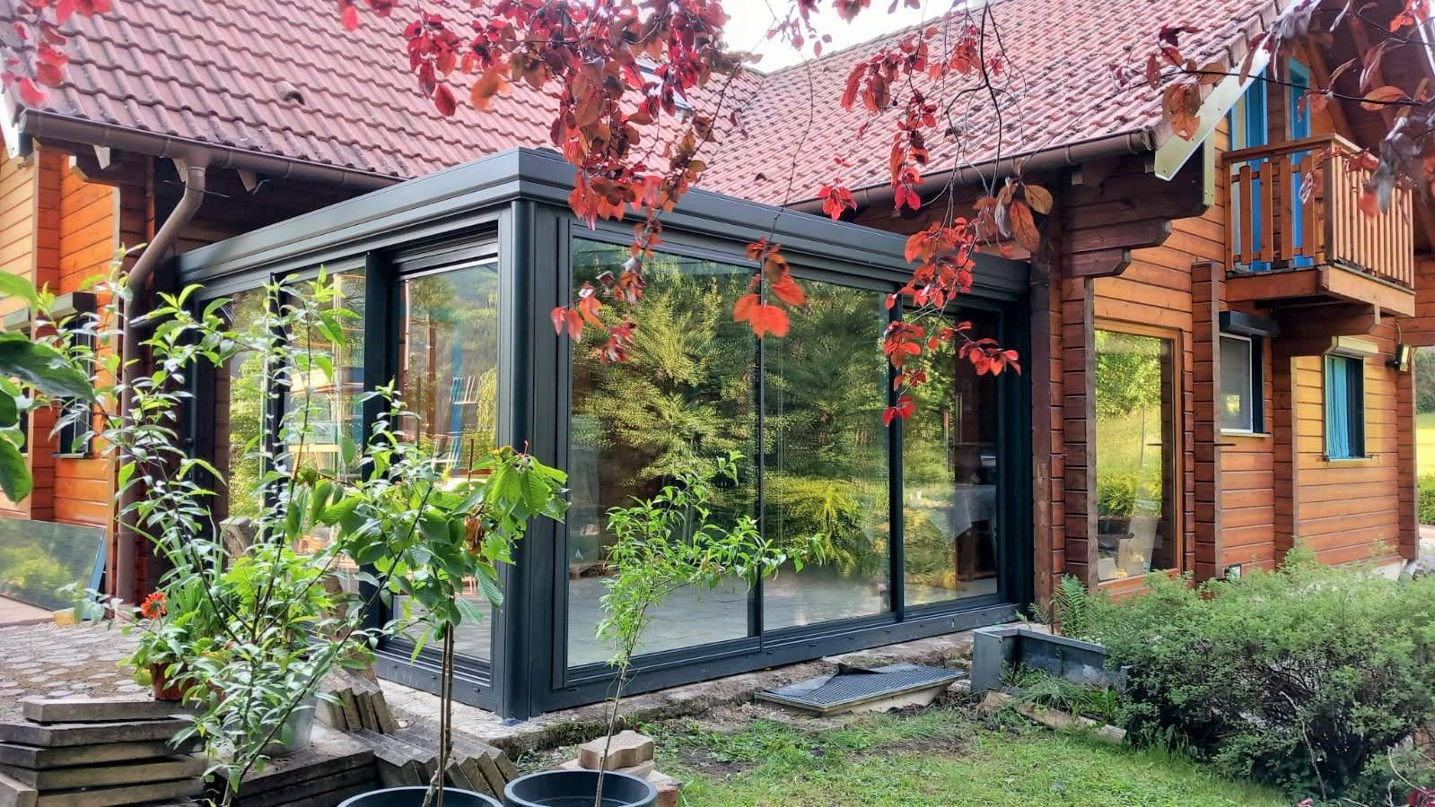Véranda moderne attenante à une maison en bois rustique.