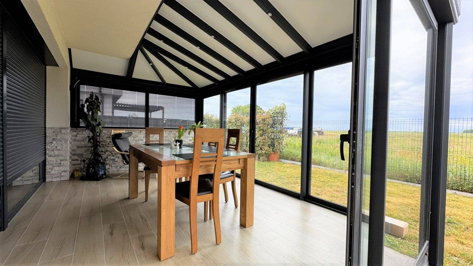 Véranda moderne avec vue panoramique sur jardin verdoyant