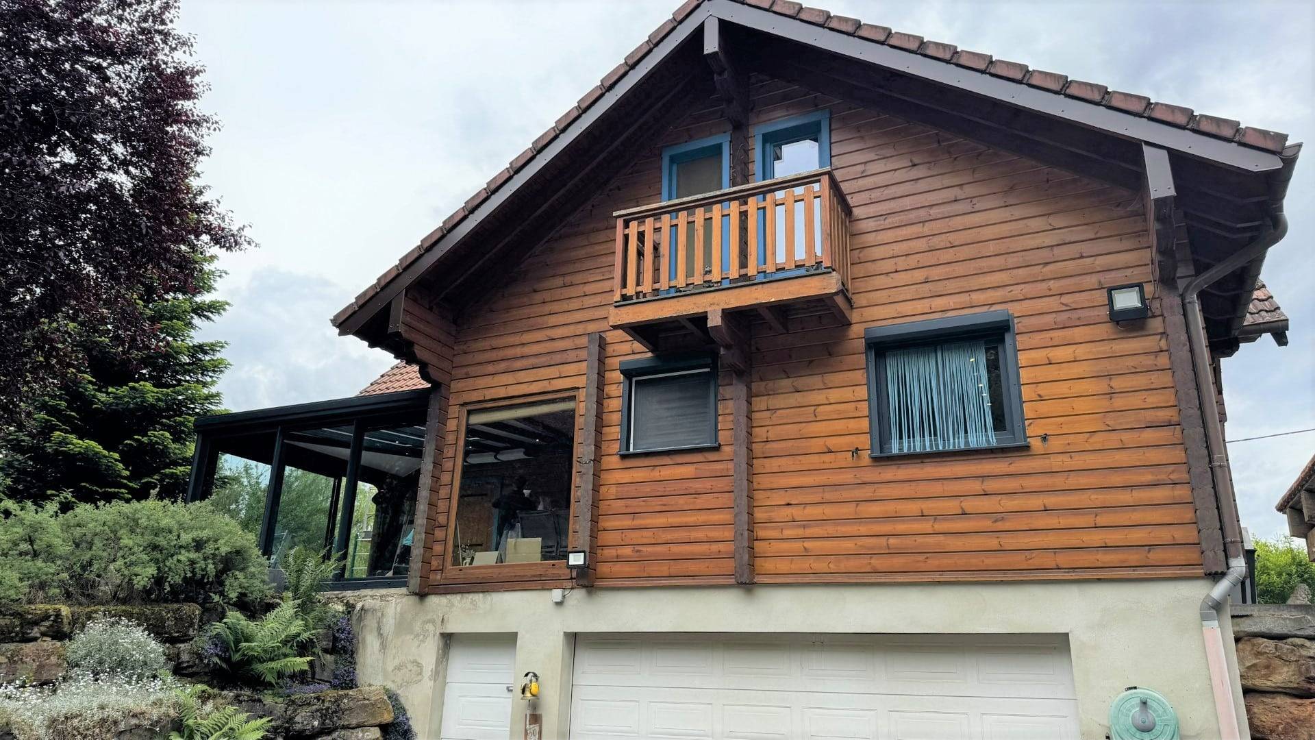 Belle véranda moderne adossée à un chalet en bois charmant