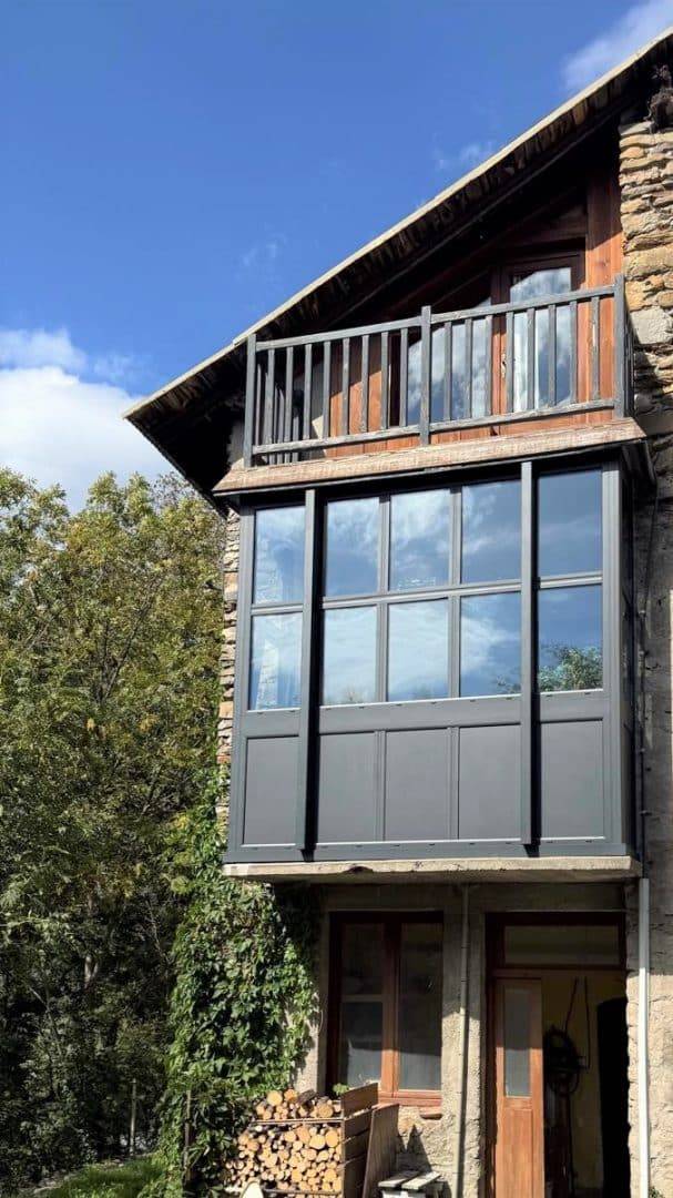 Véranda moderne en bois avec façade vitrée intégrée à la maison